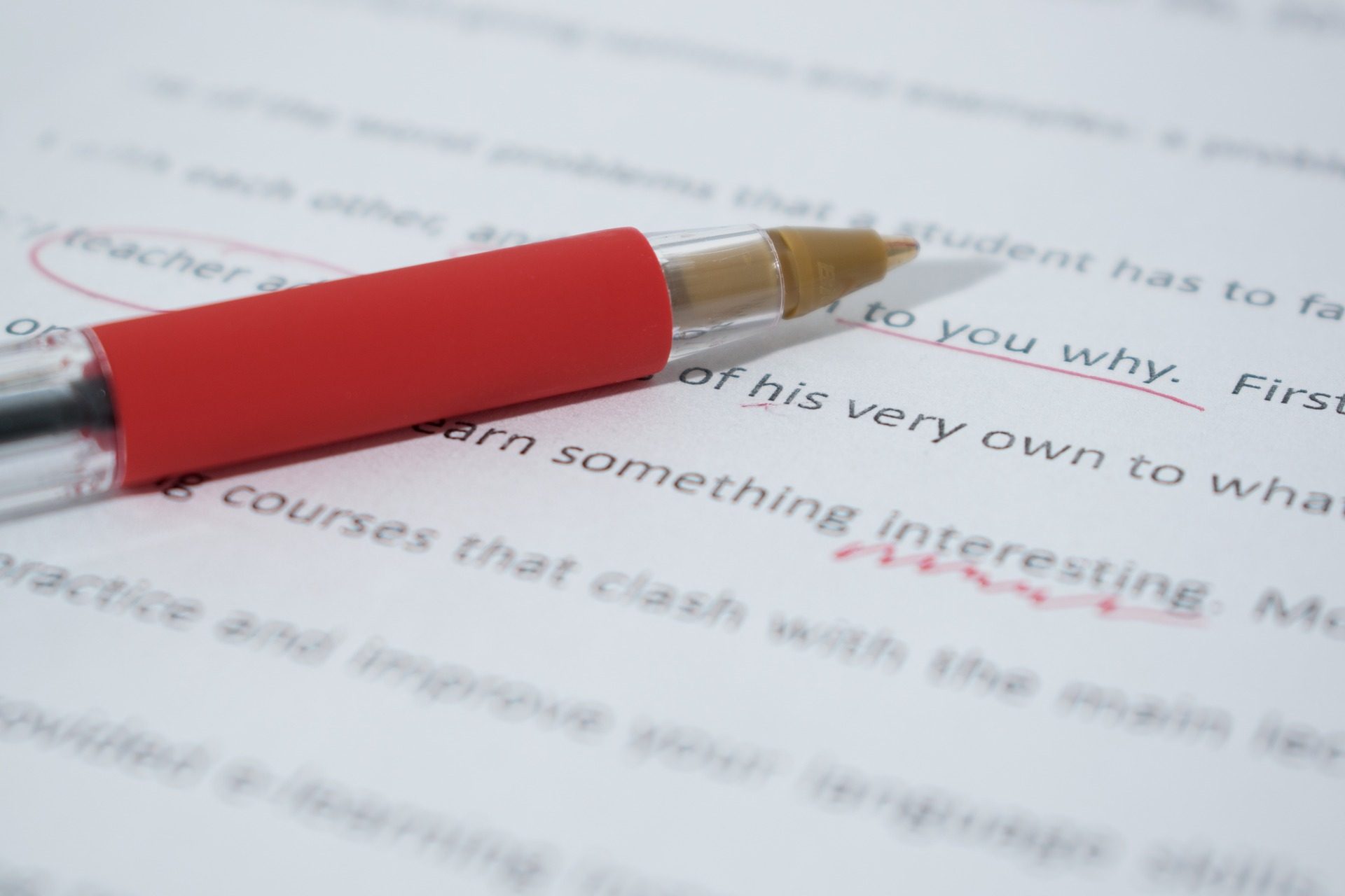 Red correction pen lying on an edited text